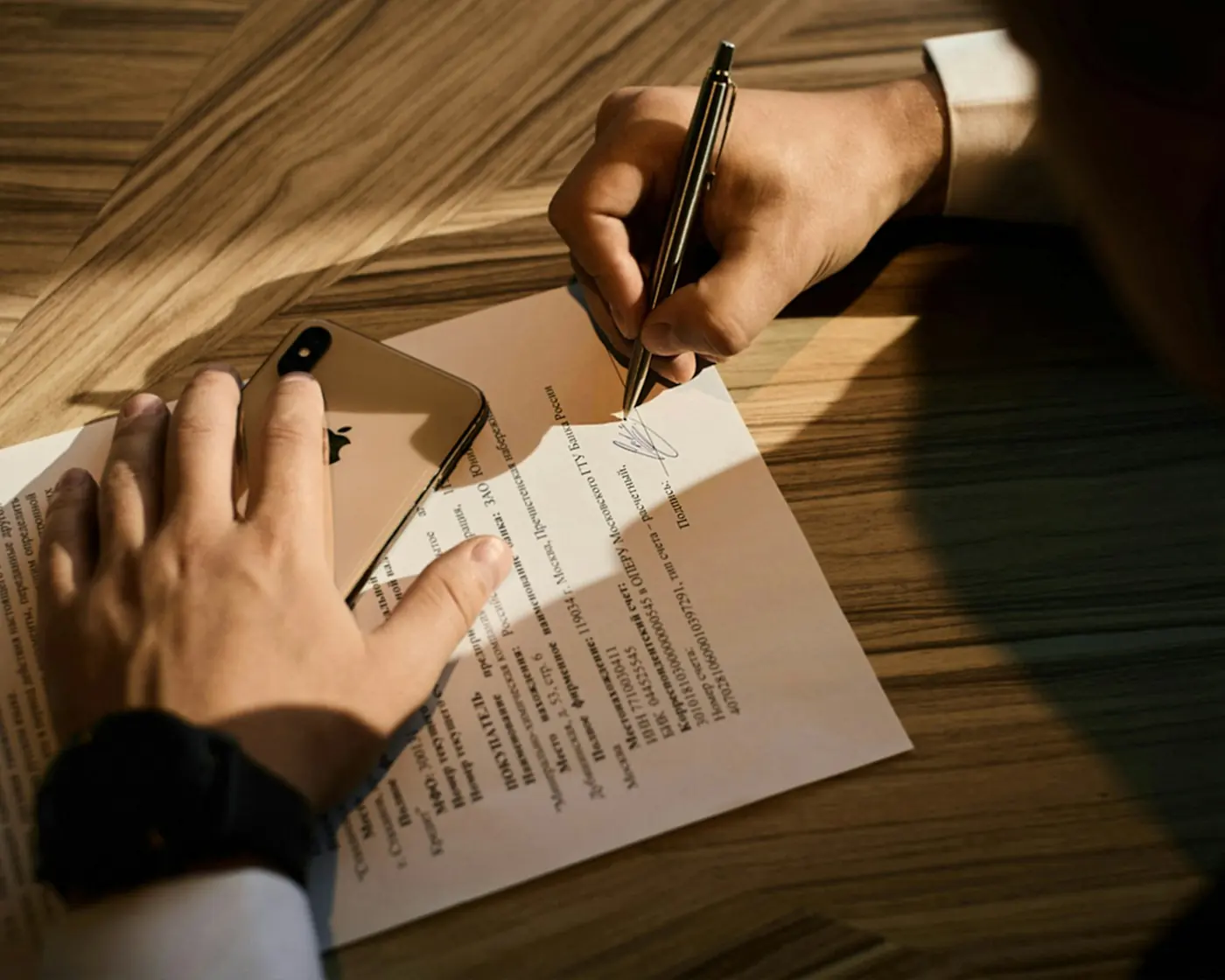 Подписание договора купли-продажи на деревянном столе
